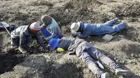 Sekelompok pria mencari di dalam keseluruhan yang mereka gali untuk apa yang mereka yakini sebagai berlian setelah penemuan batu tak dikenal di desa KwaHlathi, luar Ladysmith, Afrika Selatan (15/6/2021). (AFP/Phill Magakoe)