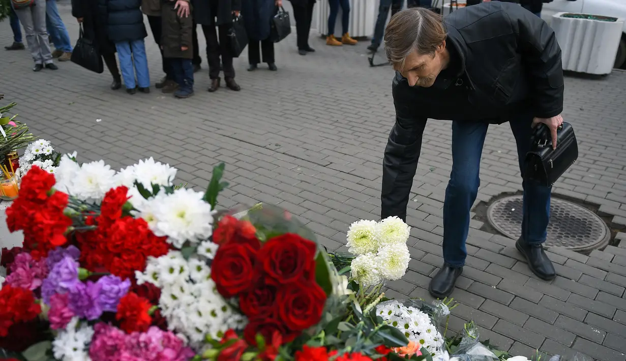 Seorang pria menaruh bunga di luar Kedutaan Besar Prancis di Moskow (4/11/2015). Serangan teroris yang terjadi di Paris telah menewaskan sekitar 140 orang. (AFP PHOTO/DMITRY SEREBRYAKOV)