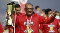 Pelatih Persija Jakarta, Sudirman, mengangkat trofi usai menjuarai Piala Menpora 2021 di Stadion Manahan, Solo, Minggu (25/4/2021). (Bola.com/M Iqbal Ichsan)