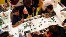 Pengunjung menyusun lego membentuk pohon natal di toko lego terbesar di dunia di Leicester Square, London, Kamis (17/11). Didalam toko lego terbesar di dunia itu banyak memamerkan berbagai benda yang terbuat dari Lego. (REUTERS/Stefan Wermuth)
