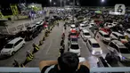 Seorang anak memperhatikan antrean mobil yang akan masuk ke dalam kapal penyeberangan di Pelabuhan Merak, Kota Cilegon, Banten, Jumat (28/3/2025) dini hari. (Liputan6.com/Herman Zakharia)