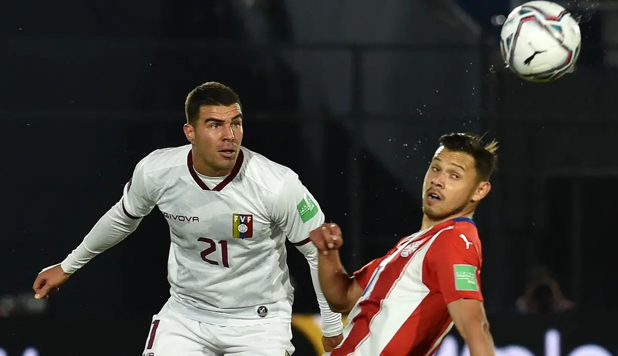 Bek Venezuela, Alexander Gonzalez dan penyerang Paraguay, Angel Romero berebut bola dalam lanjutan Kualifikasi Piala Dunia 2022 zona Conmebol di Estadio Defensores del Chaco, Asuncion, Jumat (10/9/2021) pagi. Paraguay memetik kemenangan tipis 2-1 atas Venezuela. (NORBERTO DUARTE/AFP)