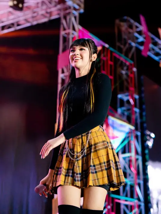 Rambutnya pun ditata dengan poni dan half ponytail serta velvet high boots. [instagram/lyodraofficial]