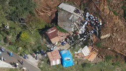 Petugas penyelamat dan polisi berusaha mencari korban usai terjadi longsor yang menghantam rumah hunian di Nakatsu, Prefektur Oita, Jepang (11/4). Longsor ini melanda kawasan pegunungan di kota Yabakei, wilayah Nakatsu. (Takuto Kaneko/Kyodo News via AP)