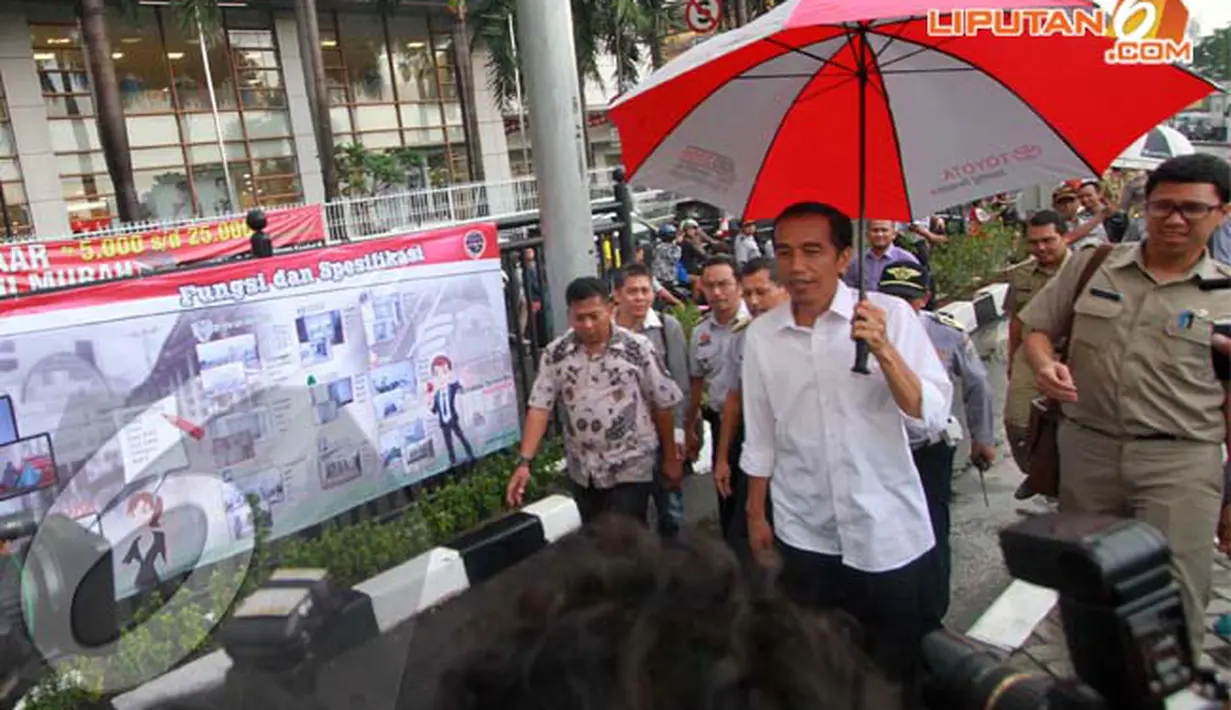Jokowi menggunakan payung saat mengunjungi Terminal Manggarai, Jakarta, Rabu (16/04/2014) Warga menyambut kedatangan Jokowi dengan antusias (Liputan6.com/Herman Zakharia).