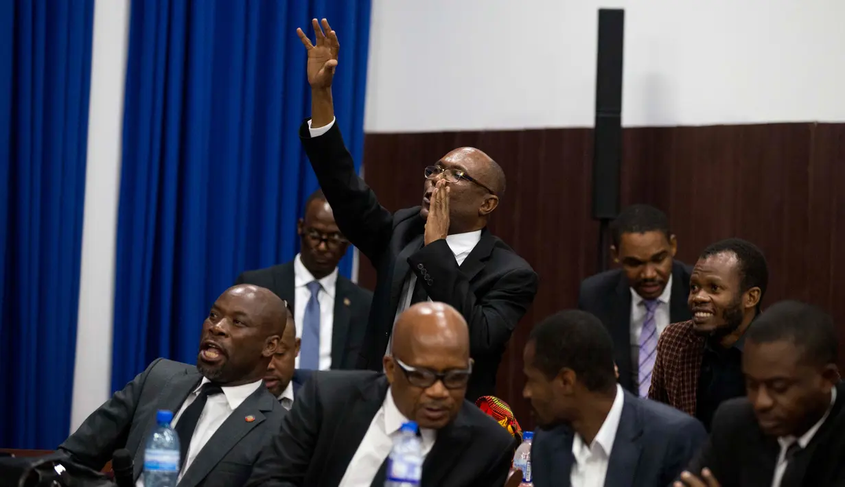 Seorang anggota parlemen melakukan interupsi saat sidang pemakzulan terhadap Presiden Haiti Jovenel Moise atas tuduhan korupsi di Port-au-Prince, Haiti, Rabu (21/8/2019). Sidang diwarnai dengan genangan air hujan pada lantai gedung parlemen karena atap yang bocor. (AP Photo/Dieu Nalio Chery)