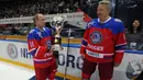 Presiden Rusia Vladimir Putin, menerima piala dari mantan pemain Soviet Alexander Yakushev usai bermain hoki es dalam acara gala game Ice Hockey League di Sochi, Rusia, 10 Mei 2016. (Reuters/ Mikhail Klimentyev/Sputnik/Kremlin)