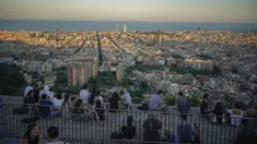 Orang-orang duduk di sudut pandang panorama kota Barcelona, Spanyol, Senin (21/10/2021). Barcelona adalah sebuah kota terbesar kedua di Spanyol dan merupakan ibu kota wilayah otonom Katalonia. (AP Photo/Joan Mateu)