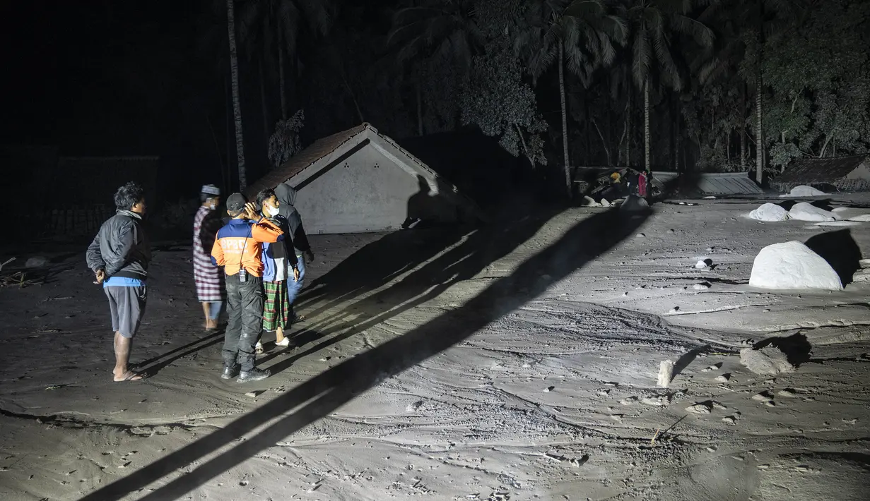 Warga dan tim penyelamat memeriksa area yang tertutup abu vulkanik dalam upaya mencari korban atau jenazah pasca erupsi Gunung Semeru di Desa Sumber Wuluh, Lumajang, Minggu (5/12/2021). (AFP/Juni Kriswanto)