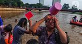 Warga melakukan tradisi keramas bersama di Sungai Cisadane di Kampung Babakan, Tangerang, Selasa (21/3/2023). (Liputan6.com/Angga Yuniar)