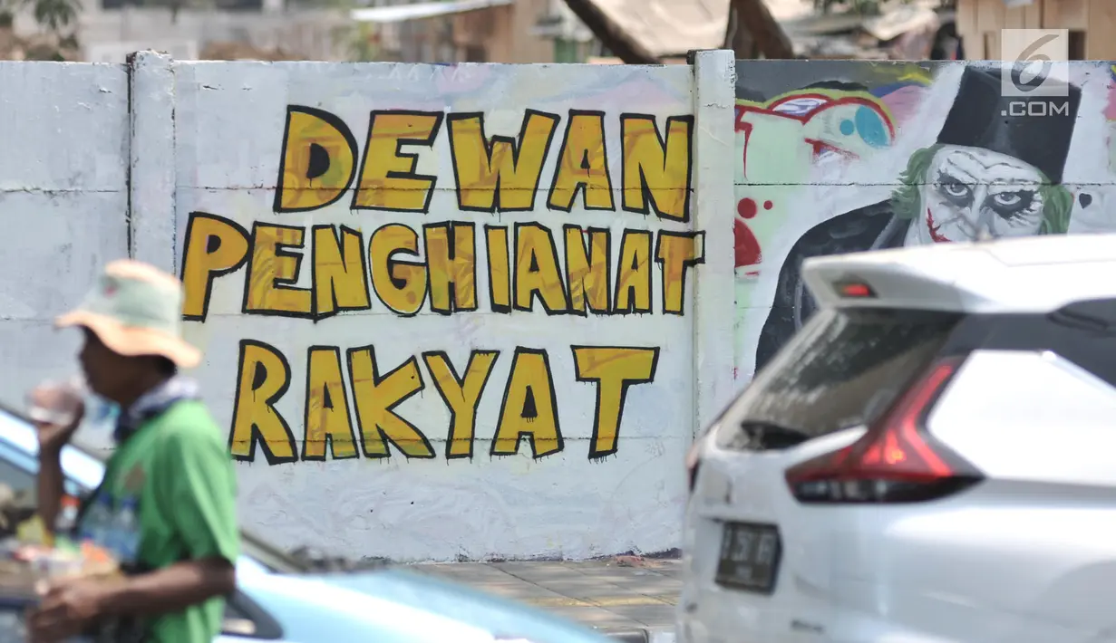 Mural bertulis 'Dewan Pengkhianat Rakyat' terpampang pada dinding di Jalan Pemuda, Rawamangun, Jakarta, Selasa (1/10/2019). Mural tersebut respons dari seniman Jakarta terhadap RUU KUHP yang dinilai mencederai tatanan demokrasi. (merdeka.com/Iqbal Nugroho)