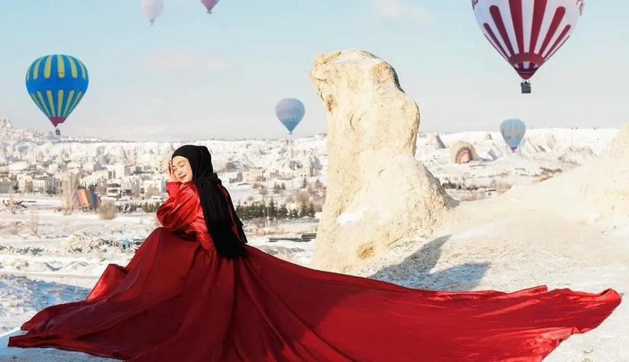 Gaun merah yang menyapu lantai tersebut dipadukan dengan hijab warna hitam. (Instagram/fdphotography90).