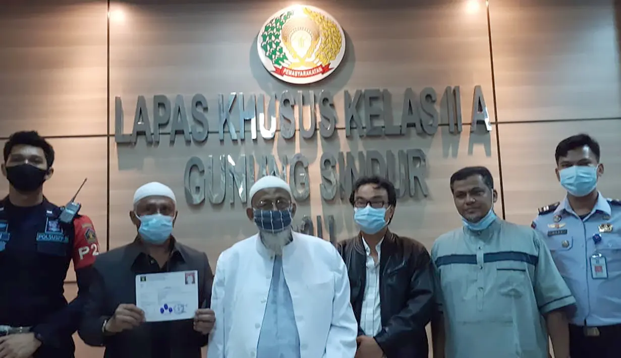 Abu Bakar Baasyir bersama petugas penjara foto bersama setelah dibebaskan dari Lapas Gunung Sindur, Kabupaten Bogor, Jawa Barat, Jumat (8/1/2021). (Handout/Indonesia National Prison/AFP)