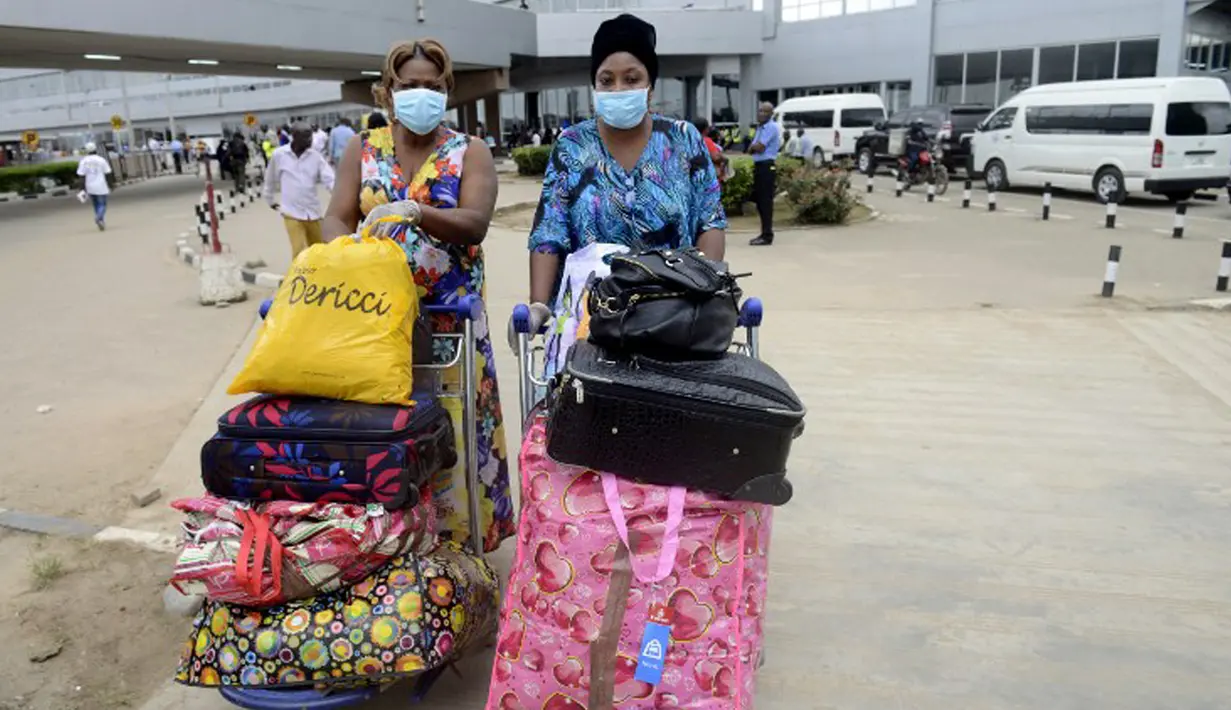 Penumpang menggunakan masker dan sarung tangan saat tiba di Bandara Murtala Mohammed, Lagos, 11 Agustus 2014. Nigeria mengkonfirmasi kasus baru Ebola yang ditemukan di Lagos. (AFP PHOTO/PIUS UTOMI EKPEI)