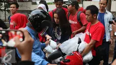 Vokalis Band Geisha Momo membagikan takjil ke pengendara yang melintas di kawasan Perdatam, Jakarta, Rabu (22/6). Memperingati bulan Ramadan Band Geisha dan Fansnya "My Geisha" membagi - bagi Takjil kepada pengendara. (Liputan6.com/Herman Zakharia)