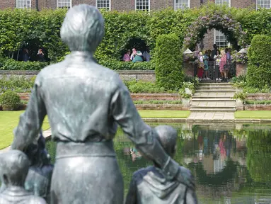 Anggota masyarakat melihat patung Dianam di Taman Sunken di Istana Kensington, London, Jumat (2/7/2021). Peresmian patung ini menandai ulang tahun ke-60 tahun Putri Diana.  (Jonathan Brady/Pool Photo via AP)