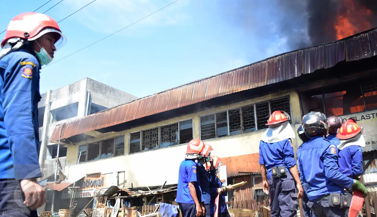 Petugas pemadam kebakaran berusaha memadamkan api yang membakar ruko di kompleks Kanjengan, Pasar Johar Semarang, Sabtu (18/6). Dugaan awal, kebakaran tersebut diakibatkan hubungan pendek arus listrik di salah satu toko di Blok E. (Liputan6.com/Gholib)