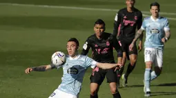 Penyerang Celta Vigo, Iago Aspas mengontrol bola di depan gelandang Real Madrid, Casemiro pada lanjutan Liga Spanyol 2020/2021 di Balaidos, Sabtu (20/3/2021). Karim Benzema jadi bintang saat Real Madrid melibas Celta Vigo 3-1. (AP Photo/Lalo R.Villar)