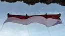 Sekelompok mahasiswa mengibarkan bendera Merah Putih berukuran besar menjelang perayaan Hari Ulang Tahun ke-77 Republik Indonesia di Pantai Lhoknga, Aceh, 16 Agustus 2022. Pengibaran bendera Merah Putih berukuran besar yang dilakukan pada sebuah tebing ini untuk memeriahkan Hari Ulang Tahun ke-77 Republik Indonesia. (CHAIDEER MAHYUDDIN/AFP)