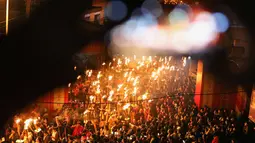 Ratusan warga memegang obor mengikuti parade untuk berdoa semoga berhasil di tahun baru saat sebuah festival obor di Jinjiang di provinsi Fujian, China timur (24/2). (AFP Photo)