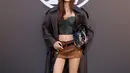 Lisa BLACKPINK tampil ala rockstar dengan korset kulit dan rok mini cokelat. Dipadukan dengan long coat kulit dan sepatu boots hitam [Louis Vuitton]