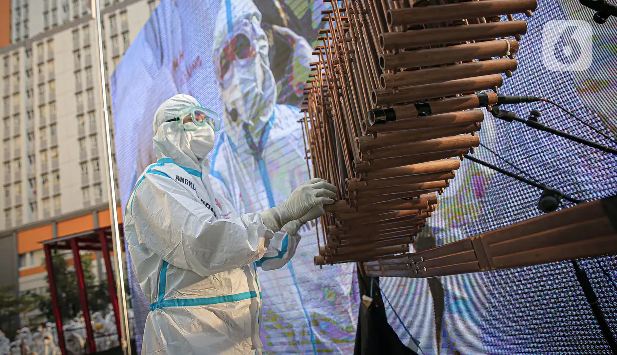 Seorang tenaga kesehatan memainkan angklung di RSDC Wisma Atlet, Kemayoran, Jakarta, Selasa (23/3/2021). Acara tersebut dilakukan dalam rangka satu tahun beroperasinya RSDC Wisma Atlet Kemayoran. (Liputan6.com/Faizal Fanani)