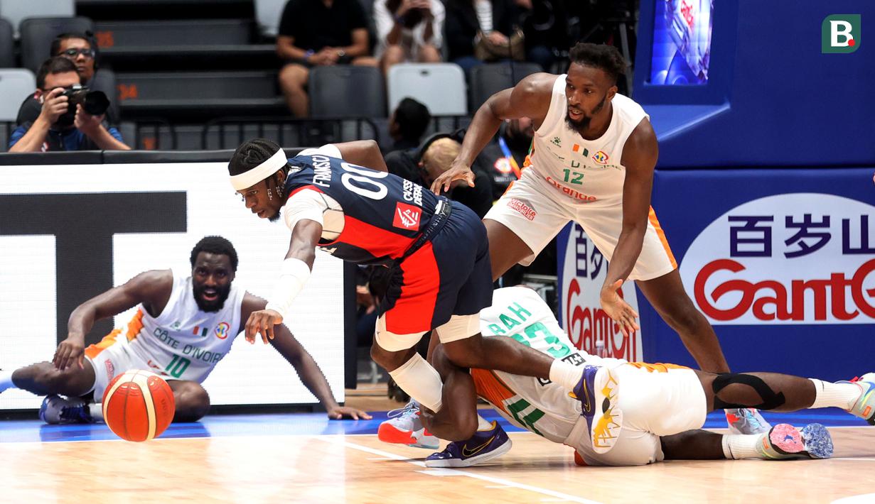 Pebasket Prancis, Sylvain Francisco, berusaha melepaskan diri dari adangan pebakset Pantai Gading pada pertandingan FIBA World Cup 2023 di Indonesia Arena, Sabtu (2/9/2023). Prancis menang dengan skor 87-77. (Bola.com/M Iqbal Ichsan)