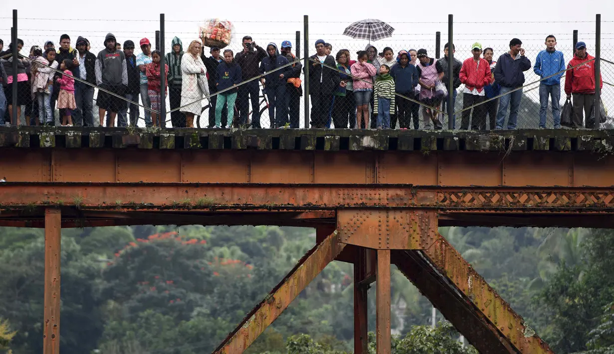 Warga memperhatikan para petugas keamanan yang mengevakuasi jenazah dari lokasi jatuhnya bus ke jurang  di Negara Bagian Veracruz, selatan Meksiko, Minggu (10/1). Sedikitnya 20 orang penumpang tewas dalam kecelakaan ini. (REUTERS/Yahir Ceballos)