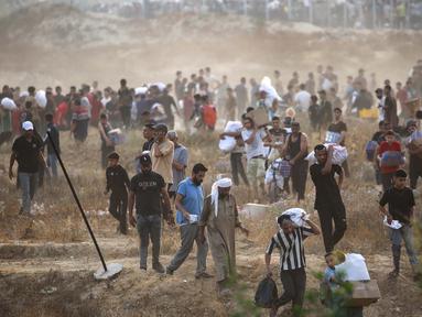 Orang-orang membawa pasokan bantuan dari Gaza Humanitarian Foundation (GHF), sebuah kelompok bantuan swasta yang didukung oleh Amerika Serikat, di Jalur Gaza Tengah pada 8 Juni 2025. (Eyad BABA/AFP)