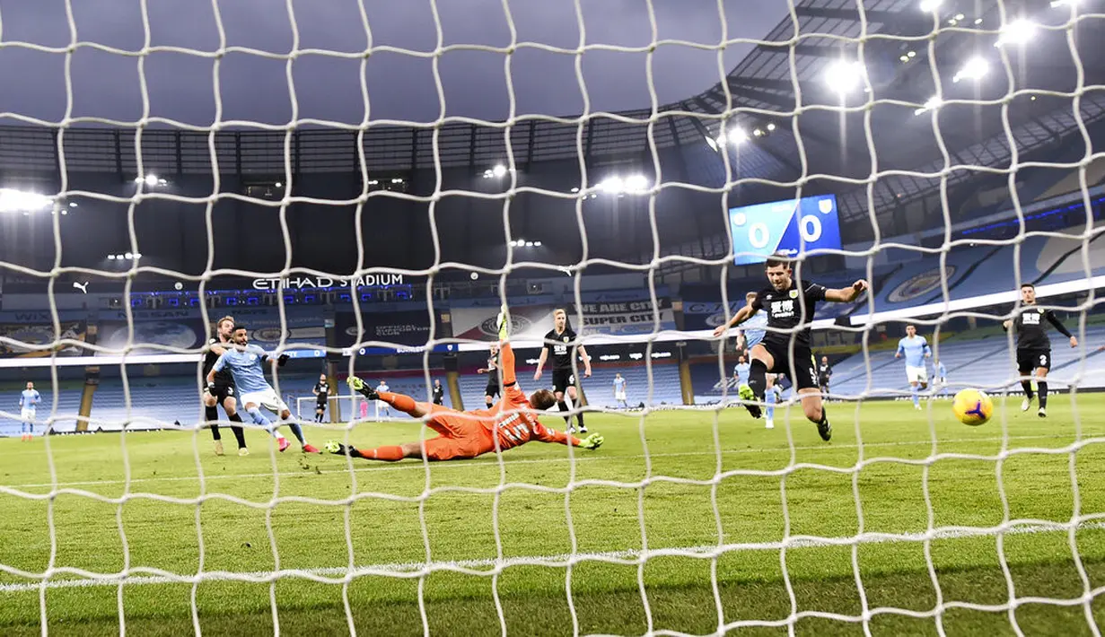 Pemain Manchester City Riyad Mahrez (kiri) mencetak gol ke gawang Burnley pada pertandingan Liga Premier Inggris di Etihad Stadium, Manchester, Inggris, Sabtu (28/11/2020). Manchester City membantai Burnley 5-0. (Laurence Griffiths/Pool via AP)