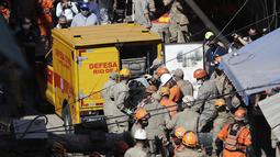 Petugas pemadam kebakaran menempatkan ke dalam kendaraan Pertahanan Sipil, tubuh ditemukan dari sebuah bangunan empat lantai yang runtuh semalam di daerah kumuh Rio das Pedras Rio de Janeiro, Brasil (3/6/2021). (AP Photo/Bruna Prado)