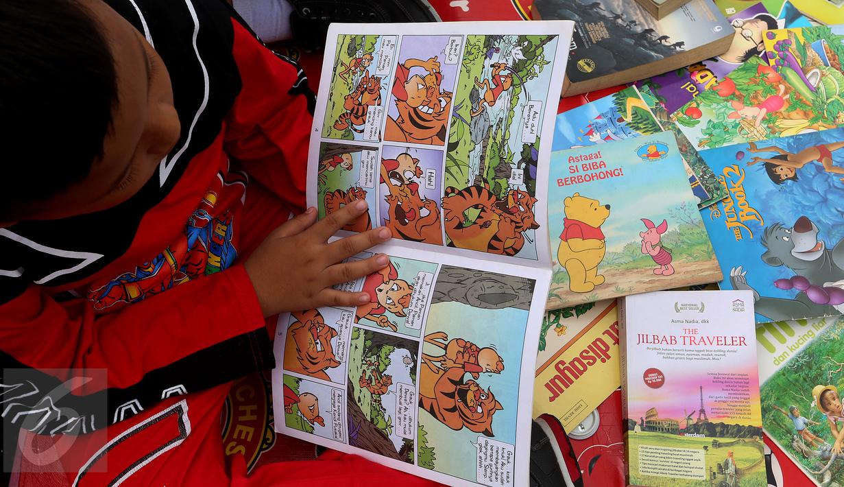 Seorang anak membaca buku di Kawasan Bundaran HI saat berlangsungnya Hari Bebas Kendaraan Bermotor, Jakarta, Minggu (2/4). Kegiatan ini dilakukan sebagai ajakan kampanye "Budayakan Membaca dari Desa untuk Indonesia". (Liputan6.com/Johan Tallo)
