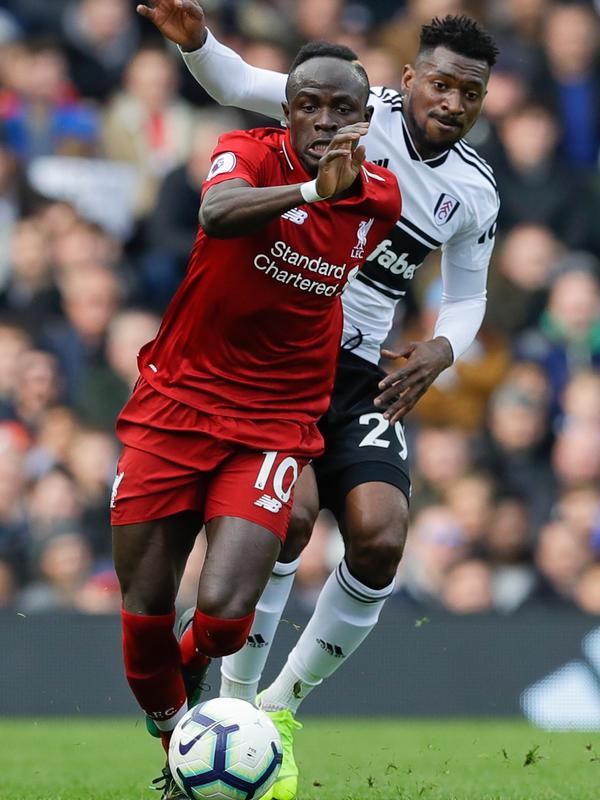 Pemain Liverpool Sadio Mane menggiring bola melewati pemain Fulham Andre-Frank Zambo Anguissa pada laga pekan ke-31 Liga Inggris di Stadion Craven Cottage, London, Minggu (17/3). Liverpool menang tipis 2-1. (AP Photo/Kirsty Wigglesworth)