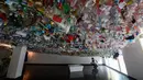 Pengunjung melihat instalasi seni yang terbuat dari sisa-sisa plastik, kaleng dan wadah di sebuah pameran "Reduce the Litter" di Hanoi (15/7/2019). Pameran ini menggambarkan polusi dari limbah rumah tangga yang menyebabkan dampak berbahaya bagi lingkungan dan kesehatan anak. (AFP Photo/Nhac Nguyen)