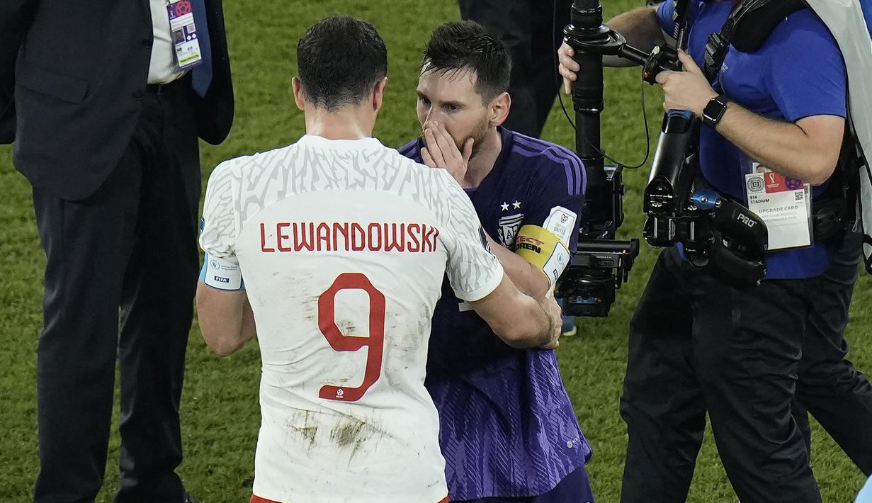 Lionel Messi pun dengan sikap profesional membalas sikap Robert Lewandowski dengan pelukan hangat sambil berbisik ke telinga striker Polandia tersebut. Entah apa yang diucapkan Lionel Messi. (AP/Hassan Ammar)