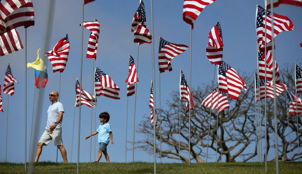 Dua orang pria berjalan diantara 3.000 bendera AS pada peringatan 15 tahun bagi para korban 11 September, 2001 di Malibu, California, (11/09). Mereka meninggal ketika tragedi pesawat  WTC, ke Pentagon serta kawasan Shanksville. (REUTERS/Lucy Nicholso)