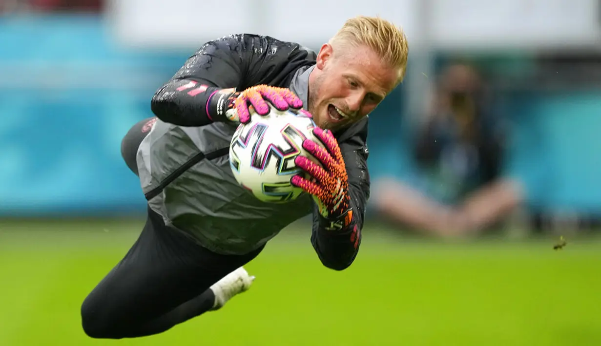 Penjaga gawang Denmark Kasper Schmeichel melompat untuk menghalau bola saat sesi latihan di Johan Cruyff Arena, Amsterdam, Belanda, Jumat (25/6/2021). Denmark akan melawan Wales pada pertandingan babak 16 besar Euro 2020. (AP Photo/Peter Dejong)