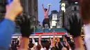 Suporter Inggris di Piccadilly Circus merayakan kemenangan Inggris atas Jerman pada pertandingan babak 16 besar Euro 2020 di London, Inggris, Selasa (29/6/2021). Inggris menang 2-0.(Yui Mok/PA via AP)