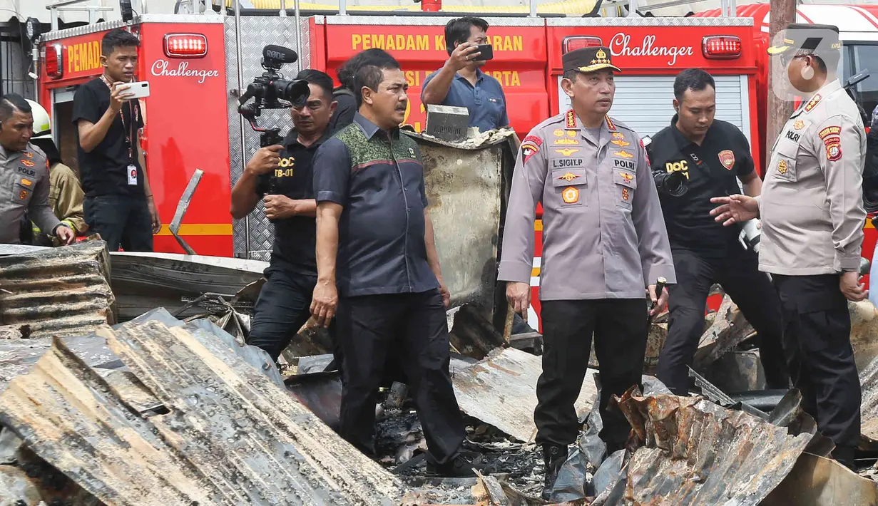 Kapolri Jenderal Listyo Sigit Prabowo berbincang saat mendatangi langsung lokasi kebakaran Depo Pertamina Plumpang, Jakarta Utara, Sabtu (4/3/2023). Setelah berdiskusi singkat, Kapolri dan rombongan langsung meninjau rumah-rumah yang kondisinya dilahap si jago merah dan hancur tak berbentuk akibat kebakaran Depo Pertamina Plumpang. (Liputan6.com/Herman Zakharia)