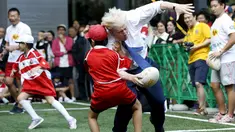 Walikota London Boris Johnson (kanan) bertabrakan dengan seorang anak selama bermain Rugby, Tokyo, Jepang, Kamis (15/10/2015).  Boris bermain Rugby untuk menyambut Jepang sebagai tuan rumah Piala Dunia Rugby 2019. (REUTERS/Issei Kato) 