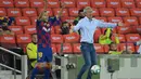 Pelatih Barcelona, Quique Setien, memberikan arahan kepada pemainnya saat menghadapi Atletico Madrid pada laga lanjutan La Liga pekan ke-33 di Camp Nou, Rabu (1/7/2020) dini hari WIB. Barcelona bermain imbang 2-2 atas Atletico Madrid. (AFP/Lluis Gene)