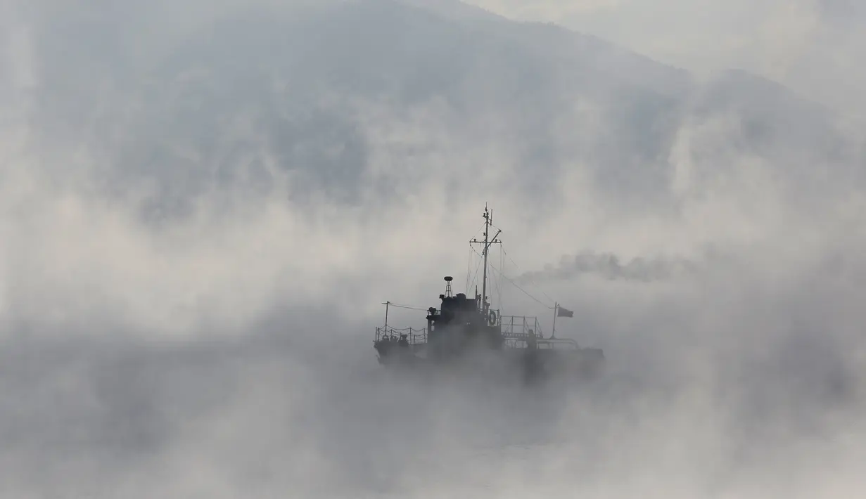 Sebuah kapal saat melintasi sepanjang Sungai Yenisei ditengah kabut dingin di Taiga luar kota Siberia Krasnoyarsk, Rusia, Selasa (17/11/2015). Suhu udara minus hingga 20 derajat Celsius. (REUTERS/Ilya Naymushin)