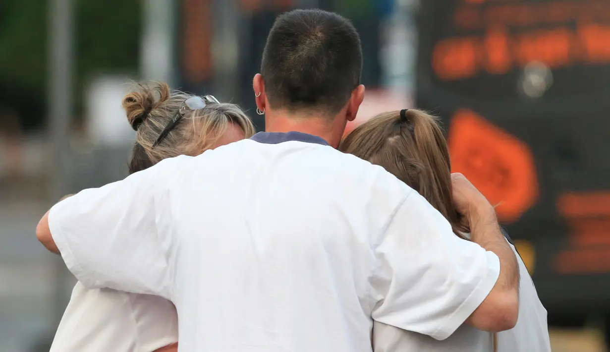 Sejumlah penggemar Ariana Grande berpelukan setelah selamat dari ledakan yang terjadi saat konser Ariana Grande di Manchester, Inggris (23/5). (AP Photo/Rui Vieira)