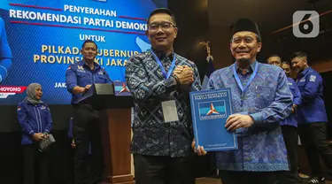 Bakal Calon Gubernur dan Bakal Calon Wakil Gubernur, Ridwan Kamil (tengah) bersama Suswono berpose usai menerima surat rekomendasi Partai Demokrat untuk maju pada Pilkada Provinsi DKI Jakarta di kantor Dewan Pimpinan Pusat (DPP) Partai Demokrat, Jakarta, Selasa (27/8/2024). (Liputan6.com/Angga Yuniar)