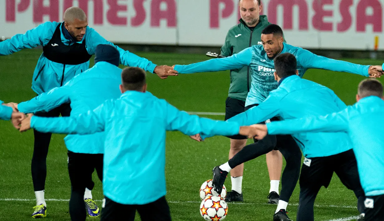 Gelandang Villarreal Etienne Capoue (kiri) dan rekan setimnya, Arnaut Danjuma menghadiri sesi latihan di Ciudad Deportiva Villarreal di Vila-Real, Senin (22/11/2021). Villarreal bakal menjamu Manchester United dalam lanjutan Liga Champions, Selasa (23/11) waktu setempat. (JOSE JORDAN / AFP)