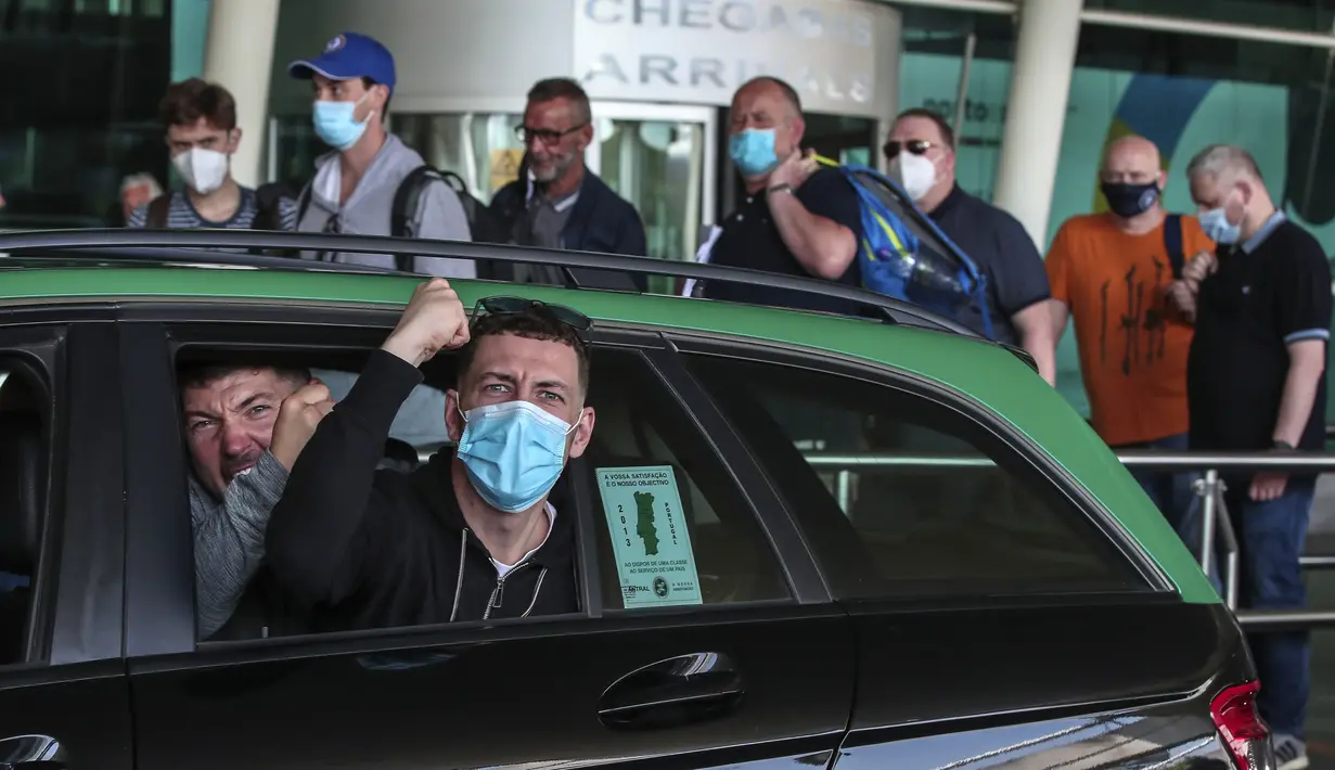 Suporter Manchester City menunjuk ke kamera dari taksi di bandara di Porto, Portugal (28/5/2021). Klub Inggris Manchester City dan Chelsea akan memainkan final Liga Champions di stadion Dragao di Porto pada Sabtu malam atau Minggu (30/5/2021) dini hari. (AP Photo/Luis Vieira)