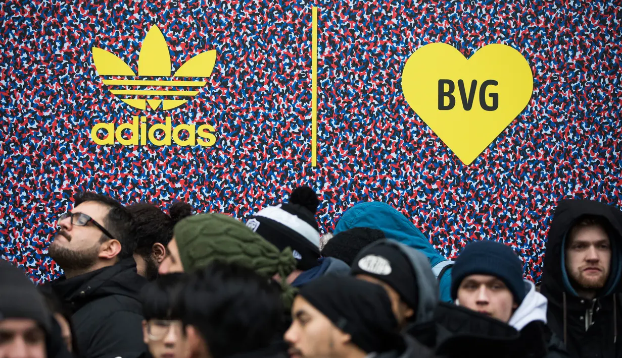 Calon pembeli mengantre untuk mendapatkan sepatu Adidas/BVG (Berlin Transport) di luar toko Overkill di Berlin, Jerman, Selasa (16/1). Sepatu tersebut dijual dengan harga 180 Euro atau sekitar Rp 2,95 juta. (AFP PHOTO / Odd ANDERSEN)
