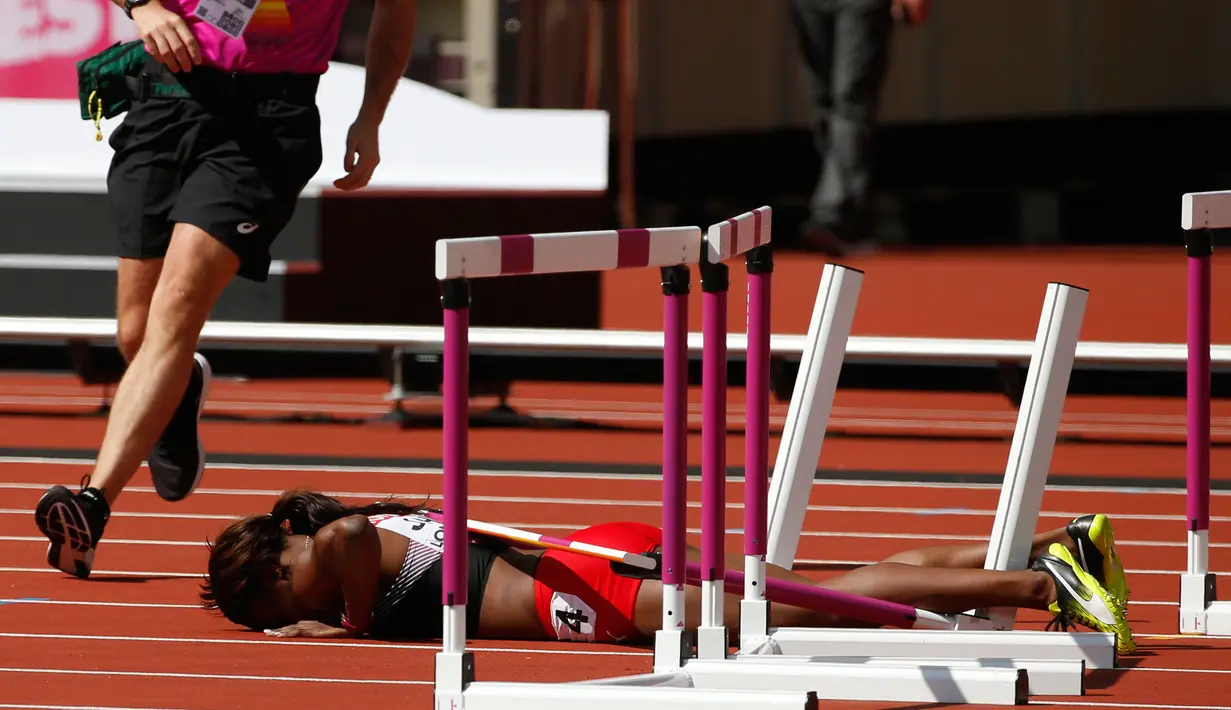 Atlet asal Trinidad dan Tobago, Deborah John tertelungkup setelah terjatuh saat melewati rintangan kelima dalam cabang lari halang rintang 100 meter putri Kejuaraan Atletik Dunia yang digelar di Stadion London, Inggris (11/8). (AP Photo/Matt Dunham)