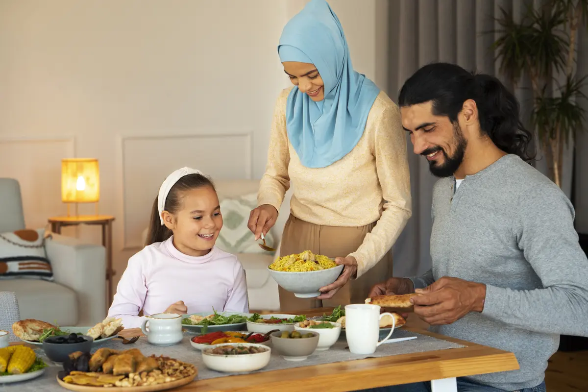 Sebuah keluarga muslim yang terdiri dari ayah, ibu, dan seorang anak sedang makan bersama (Foto Dok: Freepik/freepik)