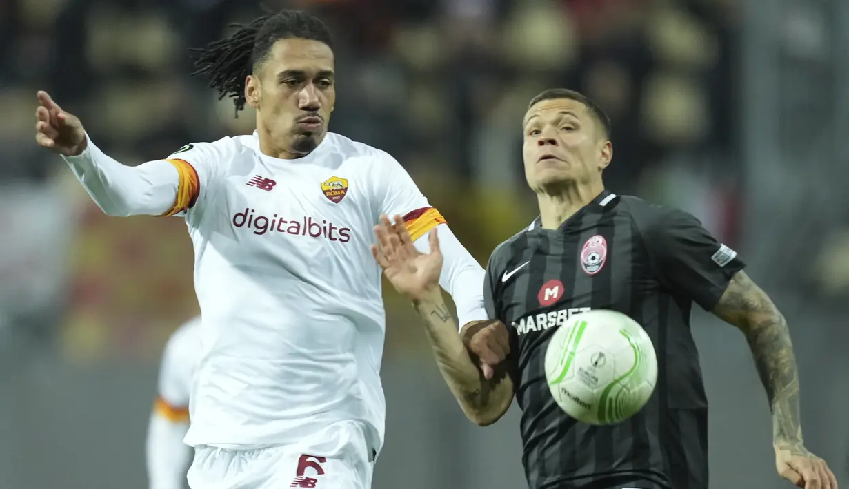 Bek AS Roma Chris Smalling berebut bola dengan gelandang Zorya Luhansk, Artem Gromov pada lanjutan matchday kedua Grup C Liga Konferensi Eropa, Jumat (1/10/2021) dini hari WIB. AS Roma menang meyakinkan 3-0. (AP Photo/Oleg Kozin)